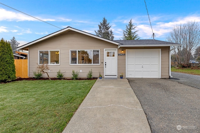 ranch-style home featuring a garage and a front lawn