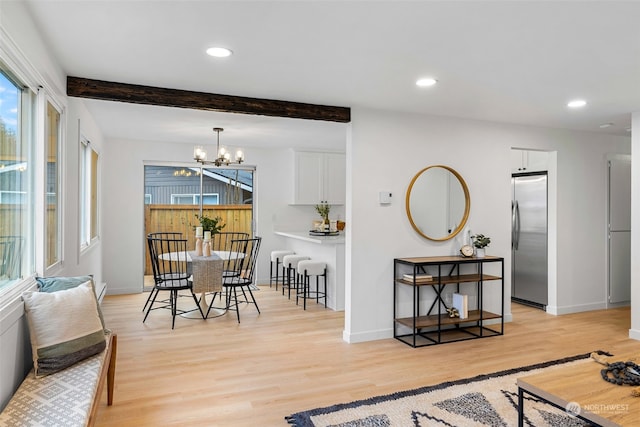 dining room with an inviting chandelier, light hardwood / wood-style flooring, and beamed ceiling