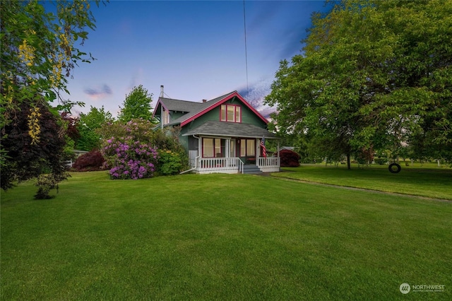 view of front of property with a porch and a yard