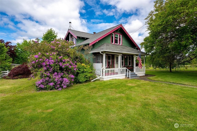 view of front of property featuring covered porch and a front lawn