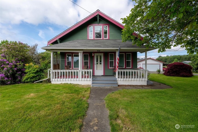 view of front facade with a front yard, a garage, covered porch, and an outdoor structure