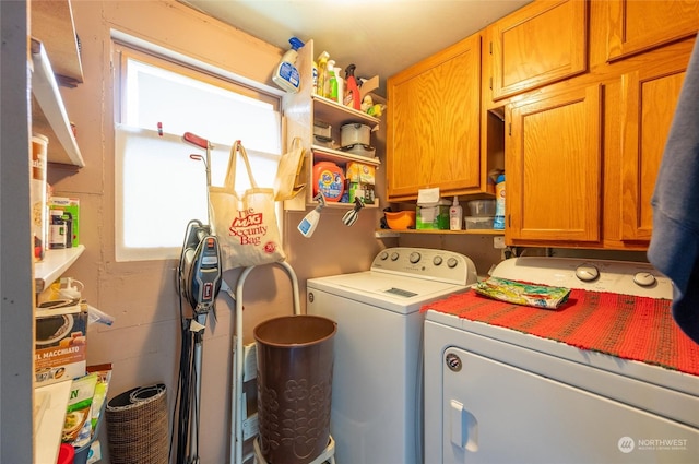 clothes washing area featuring separate washer and dryer and cabinets