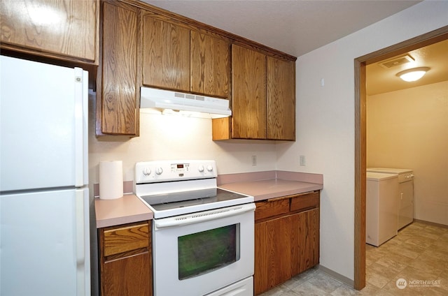 kitchen with white appliances and washer and clothes dryer