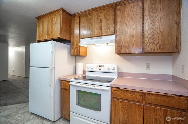 kitchen featuring light carpet, white appliances, and a textured ceiling