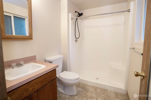 bathroom featuring vanity, a shower, and toilet