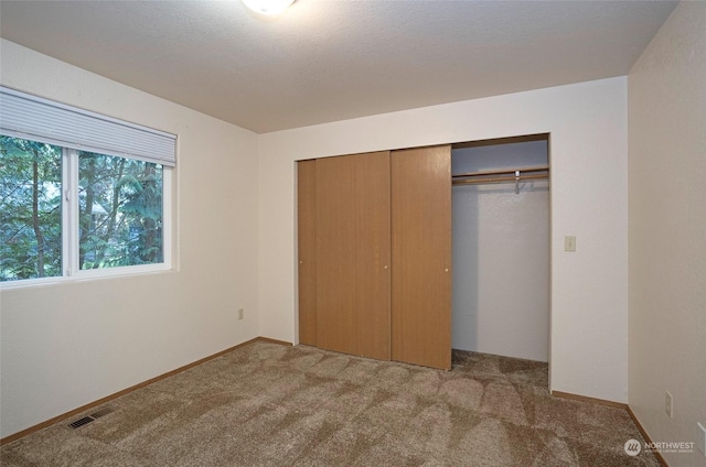 unfurnished bedroom featuring carpet and a closet