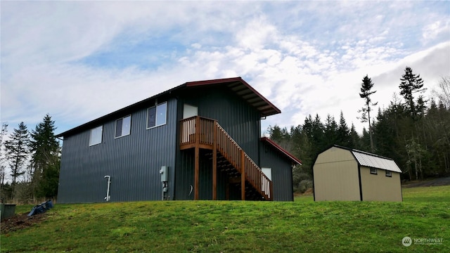 rear view of property featuring a yard and a storage shed