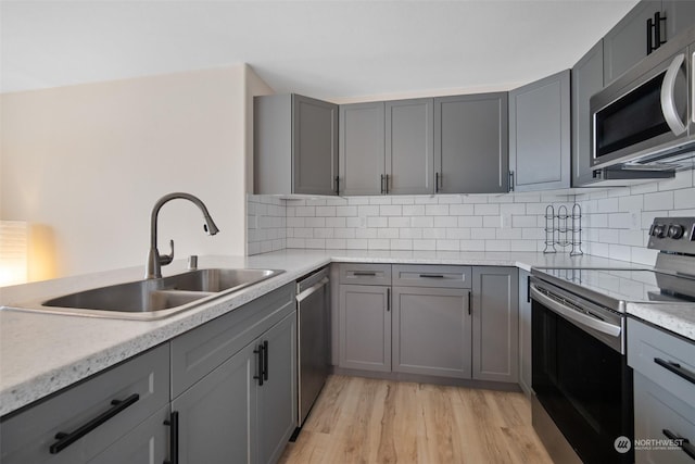 kitchen featuring gray cabinets, appliances with stainless steel finishes, and sink