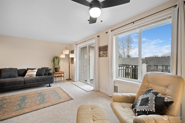 carpeted living room with ceiling fan