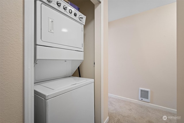 clothes washing area with stacked washer and dryer and light carpet