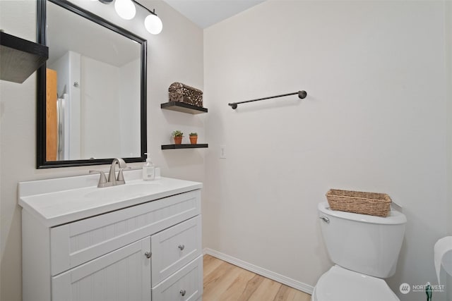 bathroom with vanity, toilet, and wood-type flooring