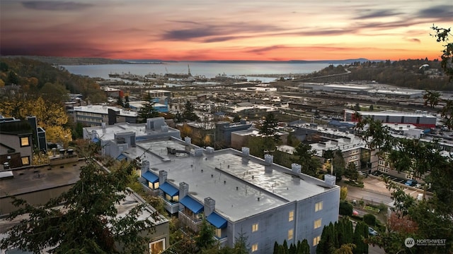 aerial view at dusk featuring a water view