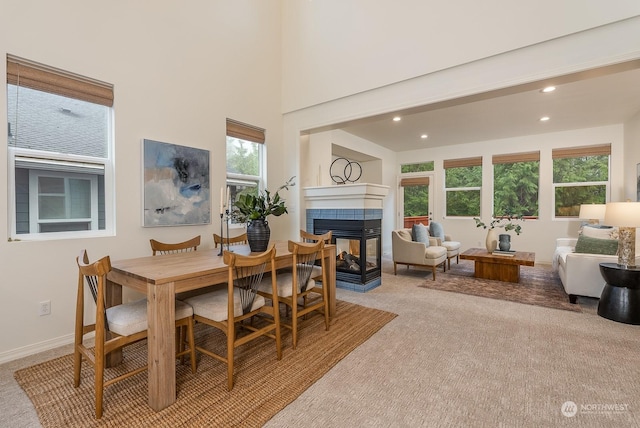 dining space with light carpet and a fireplace