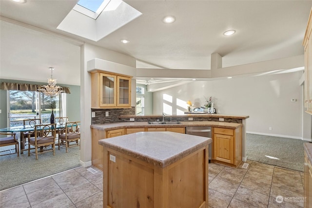 kitchen featuring sink, a center island, light carpet, light brown cabinets, and stainless steel dishwasher