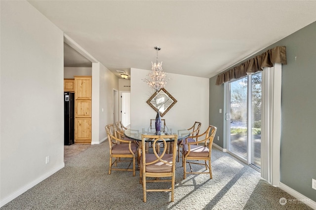 dining room featuring light carpet and a chandelier