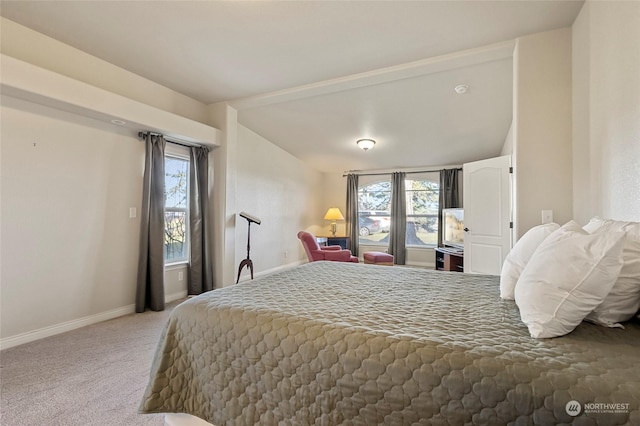 bedroom featuring multiple windows, lofted ceiling, and carpet