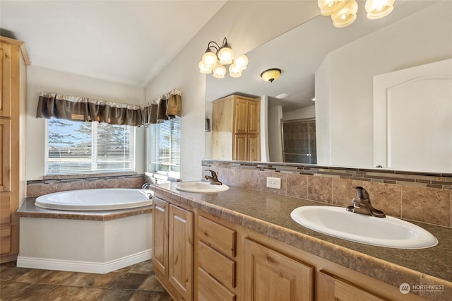 bathroom with vanity, a bath, vaulted ceiling, and backsplash