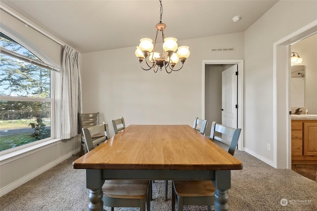 carpeted dining area featuring an inviting chandelier, sink, and lofted ceiling