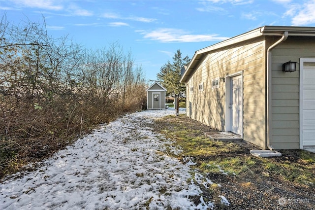 view of snow covered exterior featuring a shed