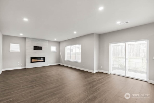 unfurnished living room featuring dark hardwood / wood-style flooring and a fireplace