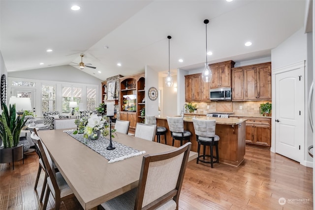 dining space featuring lofted ceiling, light hardwood / wood-style floors, and ceiling fan