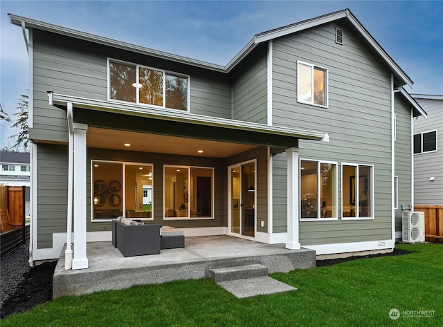 back of house featuring a lawn, an outdoor living space, and a patio