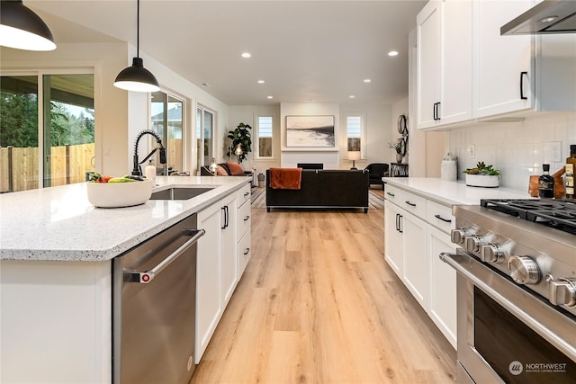 kitchen with sink, stainless steel appliances, white cabinets, and pendant lighting