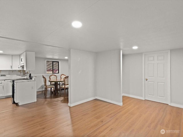 basement with light hardwood / wood-style flooring