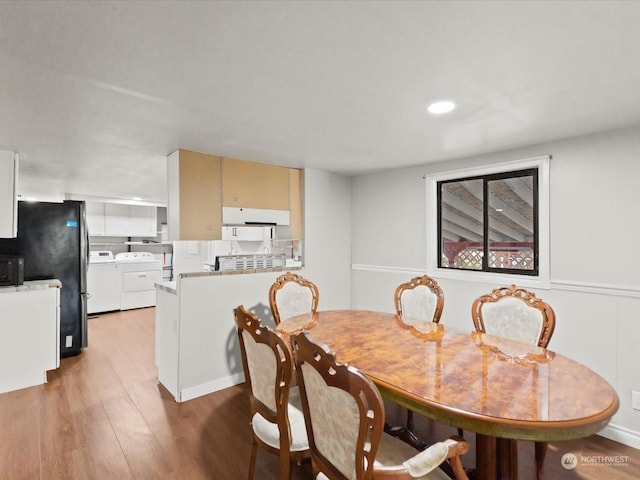 dining room featuring washing machine and dryer and wood-type flooring