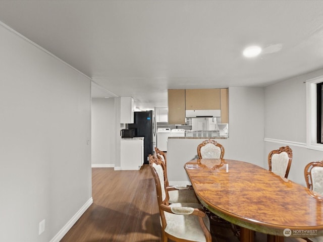 dining space featuring washing machine and clothes dryer and light hardwood / wood-style flooring