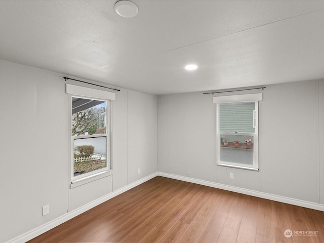 unfurnished room with wood-type flooring and a textured ceiling