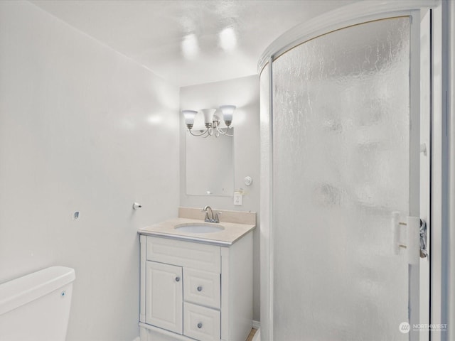 bathroom featuring a chandelier, an enclosed shower, vanity, and toilet