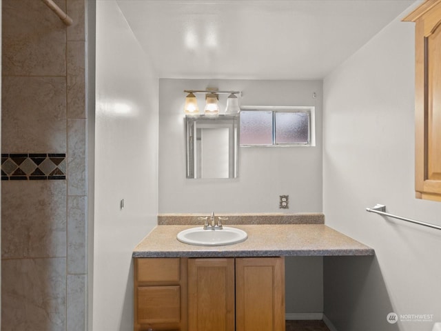 bathroom featuring a tile shower and vanity