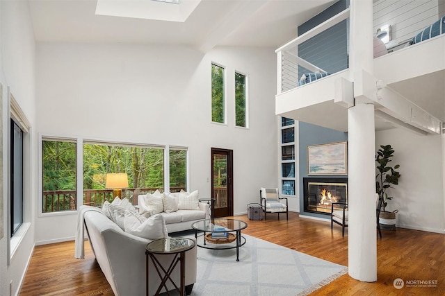 living room featuring a towering ceiling and hardwood / wood-style floors