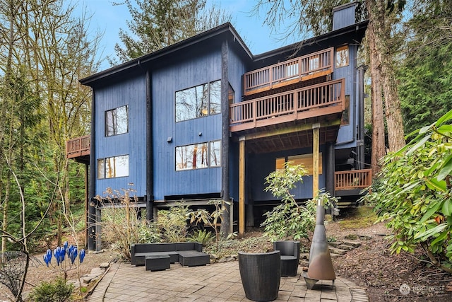 back of house with an outdoor hangout area, a patio area, and a balcony