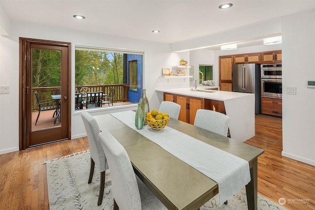 dining area featuring sink and light hardwood / wood-style flooring