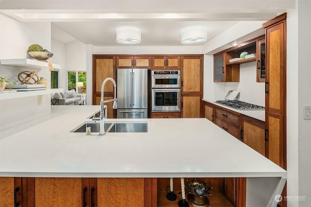 kitchen featuring stainless steel appliances, kitchen peninsula, and sink