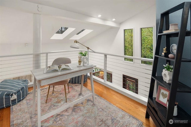 office featuring hardwood / wood-style floors and vaulted ceiling with beams