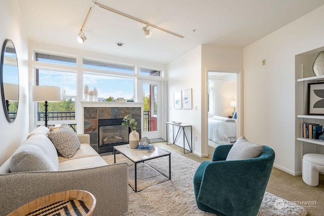 carpeted living room featuring a fireplace and rail lighting