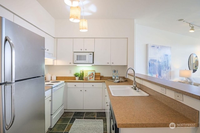 kitchen featuring sink, white cabinetry, white appliances, hanging light fixtures, and exhaust hood