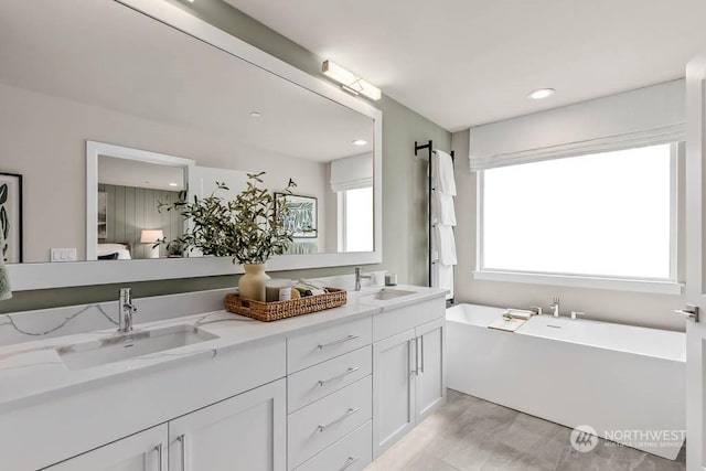 bathroom with vanity and a washtub