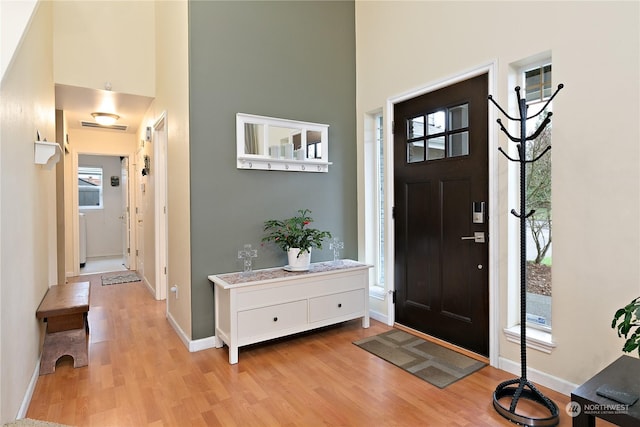 entrance foyer featuring light hardwood / wood-style flooring and a high ceiling