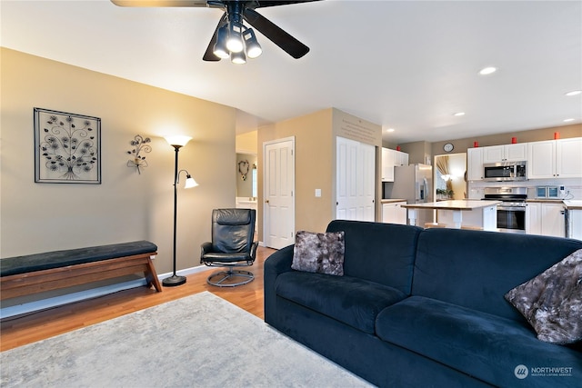 living room with ceiling fan and light hardwood / wood-style floors