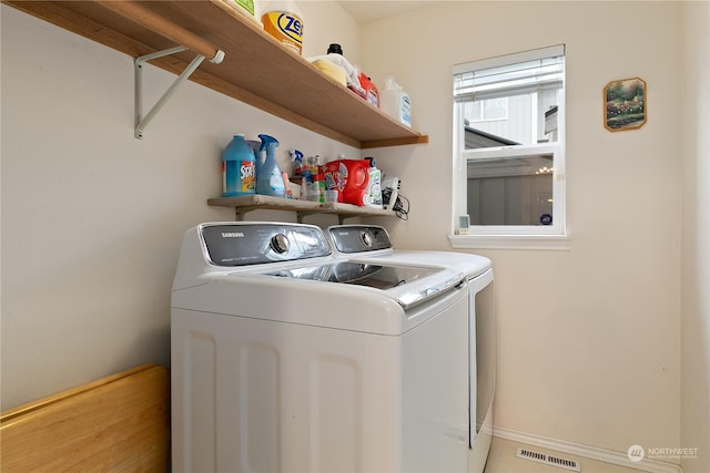 clothes washing area with washing machine and dryer