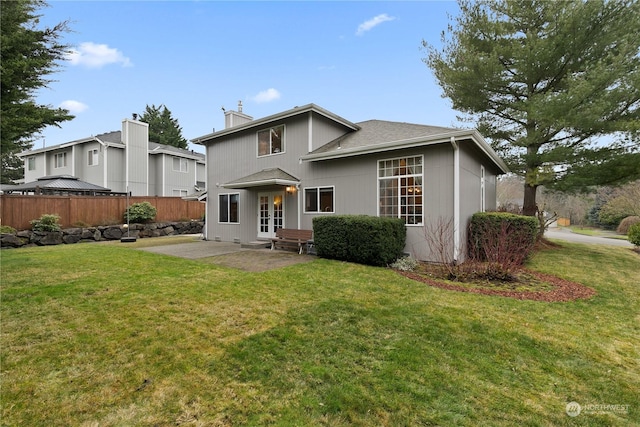 back of house featuring a patio area and a lawn