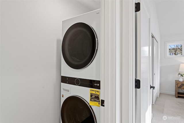 clothes washing area featuring stacked washer / dryer