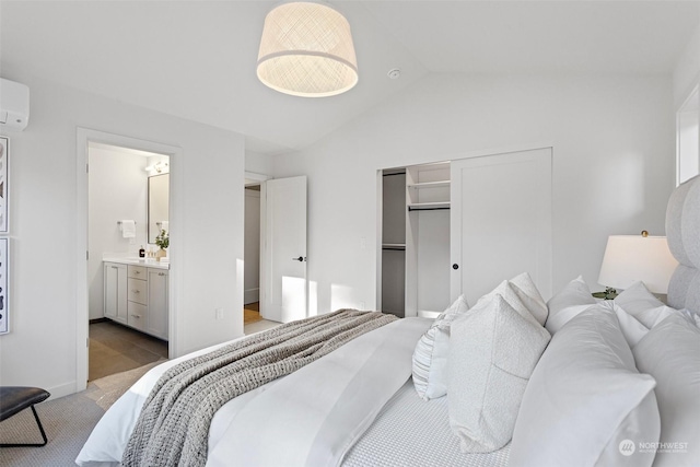 carpeted bedroom with ensuite bath, a closet, and vaulted ceiling