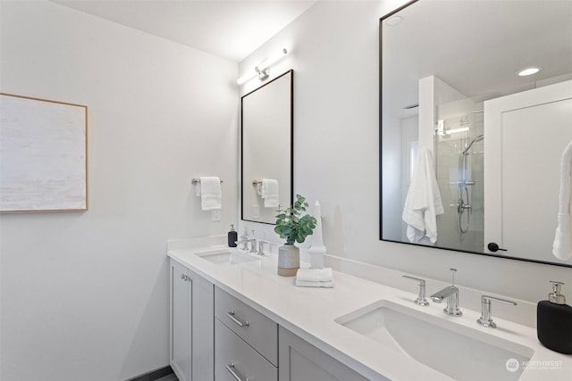 bathroom featuring a shower with door and vanity