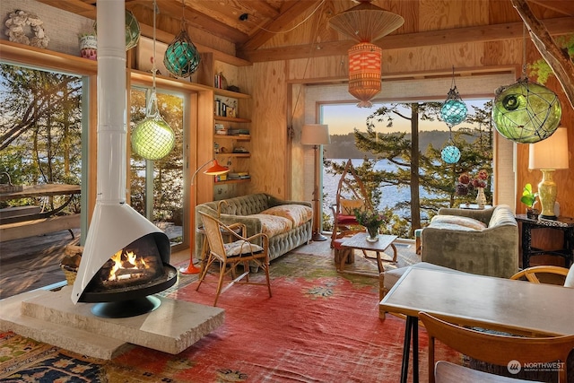 sitting room featuring a wood stove, wooden walls, wooden ceiling, and lofted ceiling with beams