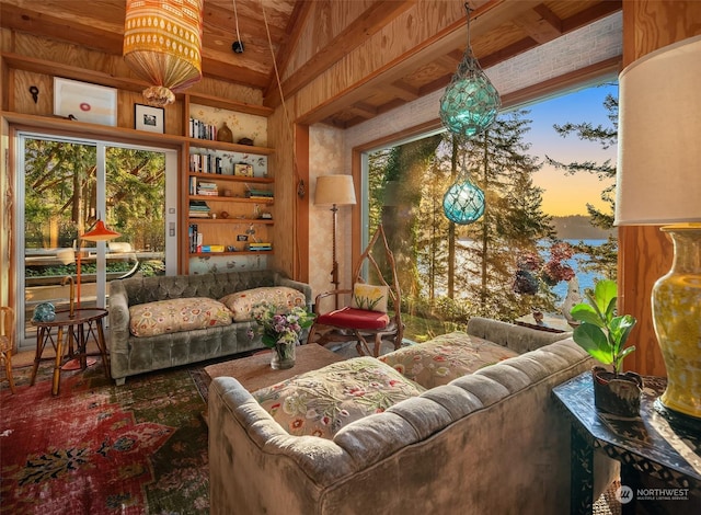 sitting room featuring wood walls and beam ceiling